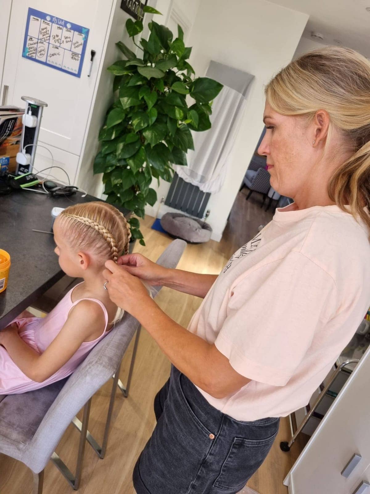 Becky braiding a girl's hair at home